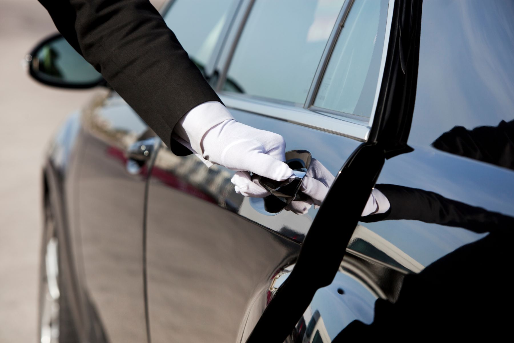 A Hand In A White Glove Opening A Car Door